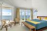 Serene primary suite with direct access to a private balcony overlooking the bay.