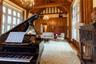 Sitting room featuring a chandelier, light wood-type flooring, high vaulted ceiling, wood walls, and a wood ceiling with exposed beams