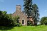 View of home's exterior featuring a chimney, a yard, and stone siding