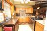 Rear building first floor Kitchen featuring gas stove, tasteful backsplash, light brown cabinets, and a chandelier