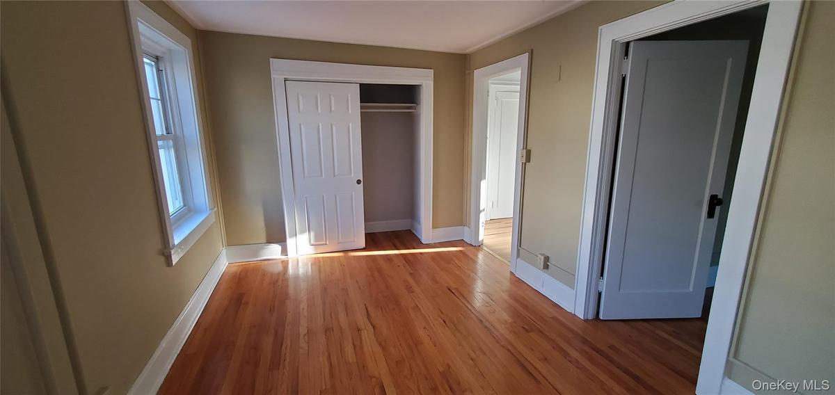 2nd Floor Front Building LR with wood flooring and a closet