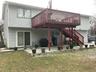Rear view of house with cooling unit, a yard, a deck, and a patio area