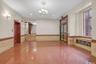 Unfurnished room featuring wainscoting, granite tiled floors, elevator, tile walls, and a chandelier