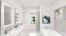 Full bath with double vanity, a soaking tub, a sink, and recessed lighting