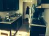 Kitchen featuring blue cabinets, exhaust hood, and dark tile patterned flooring