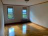 Empty room featuring plenty of natural light, ornamental molding, light wood-style flooring, and radiator heating unit