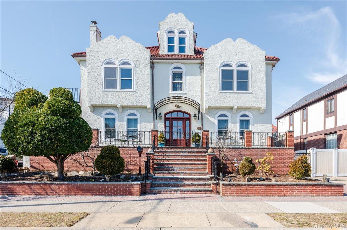 View of front of Historic, yet fully updated home featuring a red tile roof, fence, and stucco siding