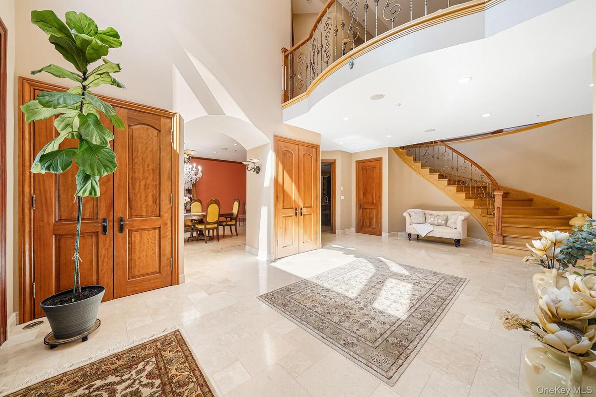 Entryway featuring stairs, arched walkways, and a towering ceiling
