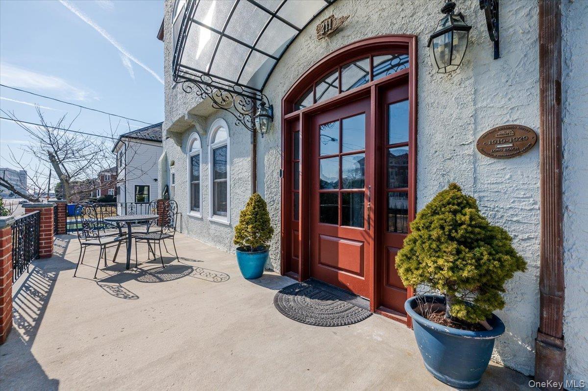 Main Entrance to home featuring awning, Large front deck, fencing, and stucco siding