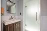 Bathroom with wainscoting, tile walls, and vanity