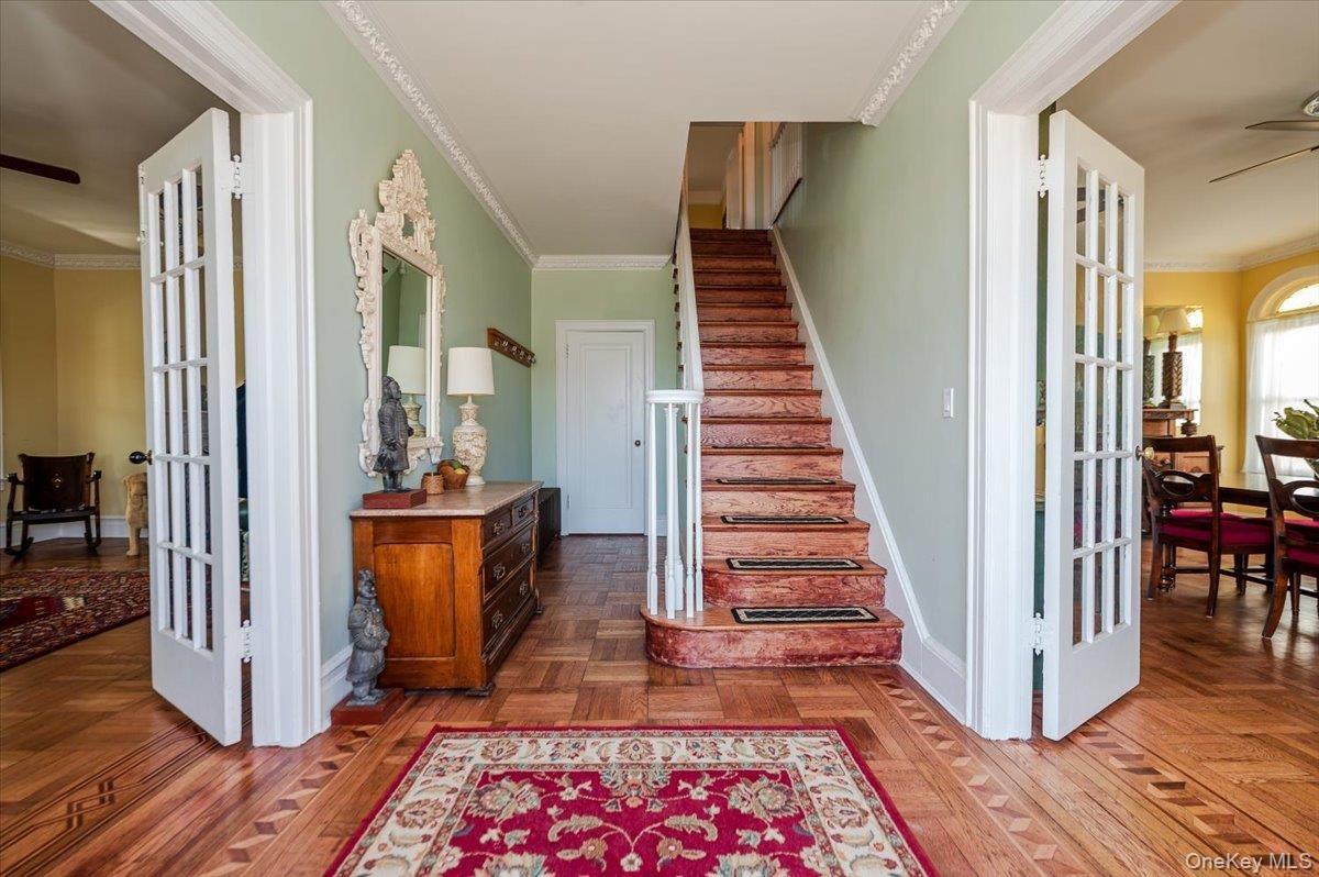 Formal Entry Foyer, Stairway with french doors to LR & DRs, custom inlaid marquetry floors, crown molding
