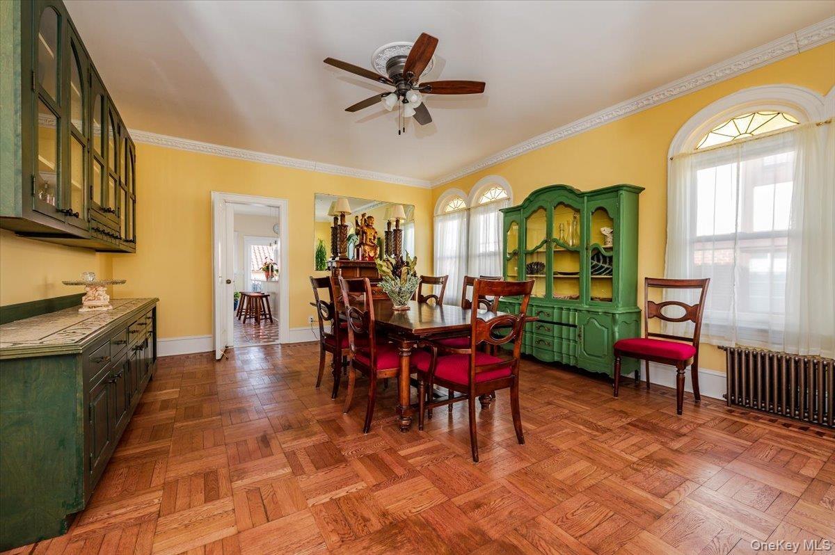Formal Dining Room featuring inlaid hardwood floors, crown molding, a wealth of natural light, and high floor moldings.