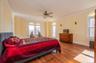 King sized, Sun-filled Primary Bedroom featuring ornamental molding, wood floors, ensuite bathroom, and private oceanview terrace