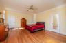 Large & Bright Primary Bedroom w wood flooring, a ceiling fan, ensuite full bath, and access to private south facing oceanview terrace