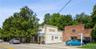 Four storefronts, plus brick office building and oversized detached garage. Off street parking