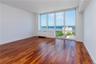 Unfurnished room with dark wood-type flooring and a water view