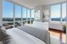 Bedroom with radiator heating unit, expansive windows, and wood-type flooring