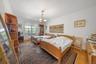 Bedroom featuring wood finished floors, radiator heating unit, and a chandelier
