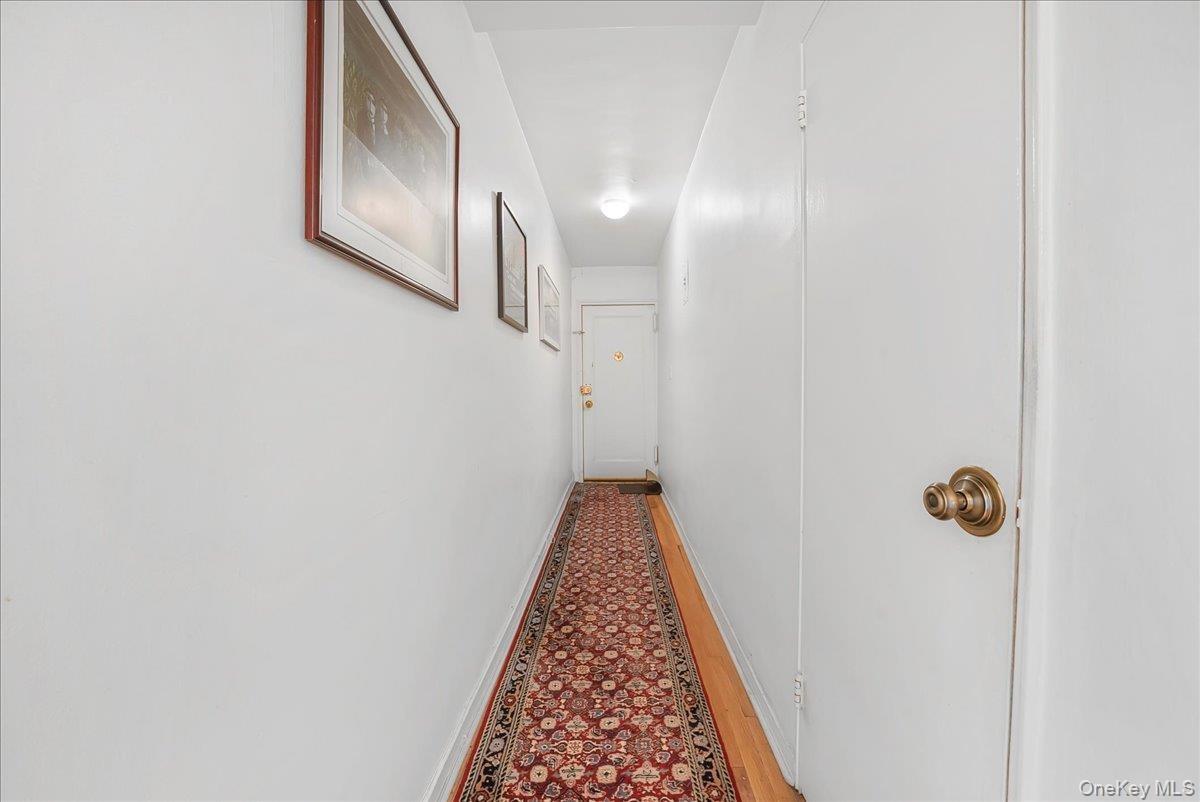 Corridor with baseboards and wood finished floors
