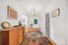 Corridor with crown molding, a chandelier, and light wood-type flooring
