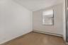 Empty room with light hardwood / wood-style floors, a textured ceiling, and baseboard heating