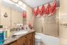Full bathroom with vanity, tile walls, enclosed tub / shower combo, and toilet
