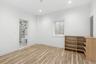 Unfurnished bedroom featuring light wood finished floors, recessed lighting, electric panel, and connected bathroom