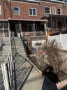 Townhome / multi-family property with brick siding, covered porch, and stairs
