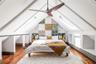 Bedroom with a skylight, a baseboard radiator, wood-type flooring, vaulted ceiling, and baseboards
