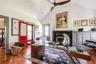 Office featuring lofted ceiling, hardwood / wood-style flooring, a fireplace, and a ceiling fan