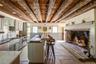 Kitchen featuring a sink, stone tile flooring, appliances with stainless steel finishes, wood ceiling, and a center island