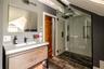 Full bathroom featuring vanity, a stall shower, lofted ceiling, and wood finished floors