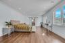 Second Floor Primary Bedroom with Ensuite Spa Bathroom, Office behind  barn door, wood finished floors, recessed lighting, and ornamental molding