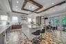Kitchen featuring modern cabinets, beverage cooler, backsplash, a breakfast bar, and wall chimney exhaust hood