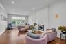 Living room with crown molding, wood finished floors, a large fireplace, and recessed lighting