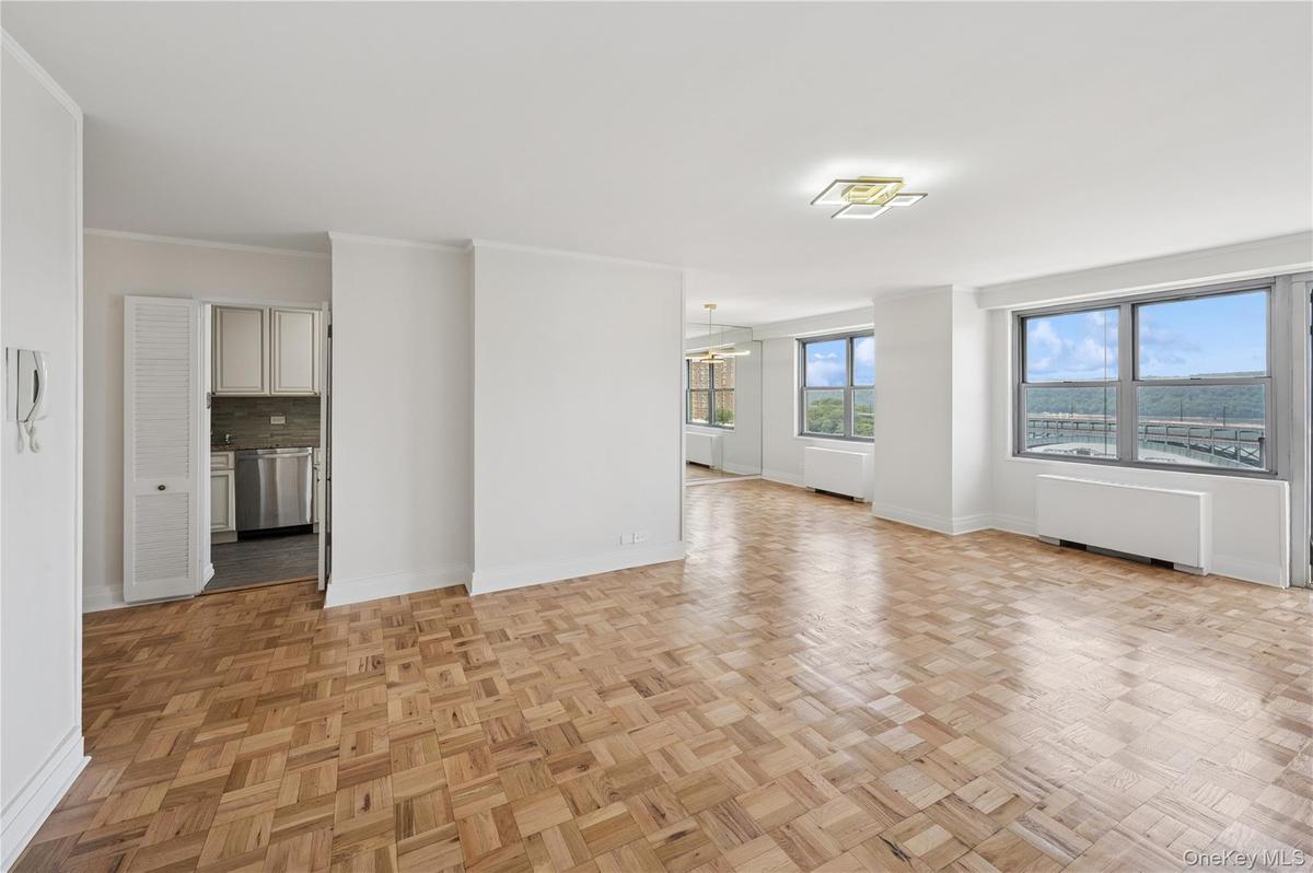 Unfurnished living room with radiator, a chandelier, and ornamental molding