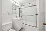 Full bathroom with marble look tiles, vanity, tile walls, and bath / shower combo with glass door