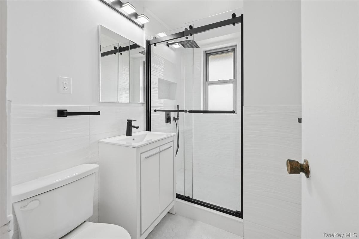 Bathroom featuring vanity, a stall shower, and tile walls