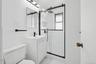 Bathroom featuring vanity, a stall shower, and tile walls