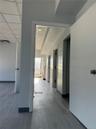 Hall with wood finished floors and a drop ceiling