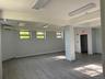 Below grade area featuring wood finished floors, a baseboard radiator, and a wall unit AC