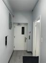 Hall with light wood-type flooring, elevator, and electric panel