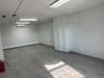 Basement with dark wood-style flooring, a baseboard radiator, and a wall unit AC