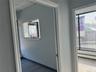 Hallway featuring a baseboard heating unit, a drop ceiling, and wood finished floors