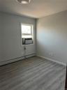 Spare room with wood finished floors and a baseboard radiator
