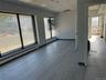 Empty room featuring baseboard heating, a drop ceiling, and wood finished floors