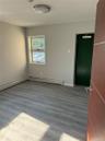 Empty room featuring wood finished floors and a baseboard radiator