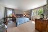 Bedroom featuring ornamental molding, wallpapered walls, and carpet flooring