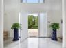 Entrance foyer featuring light tile patterned floors and a towering ceiling