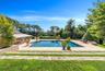 Swimming pool with a patio area and view of scattered trees